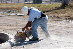 Worker cutting concrete with heavy-duty saw