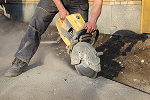 Worker cutting concrete with heavy-duty saw