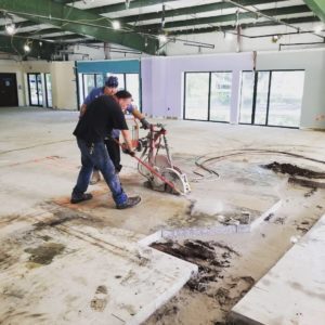 Two workers sawing a concrete floor