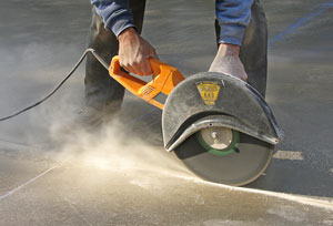 Worker cutting concrete with heavy-duty saw